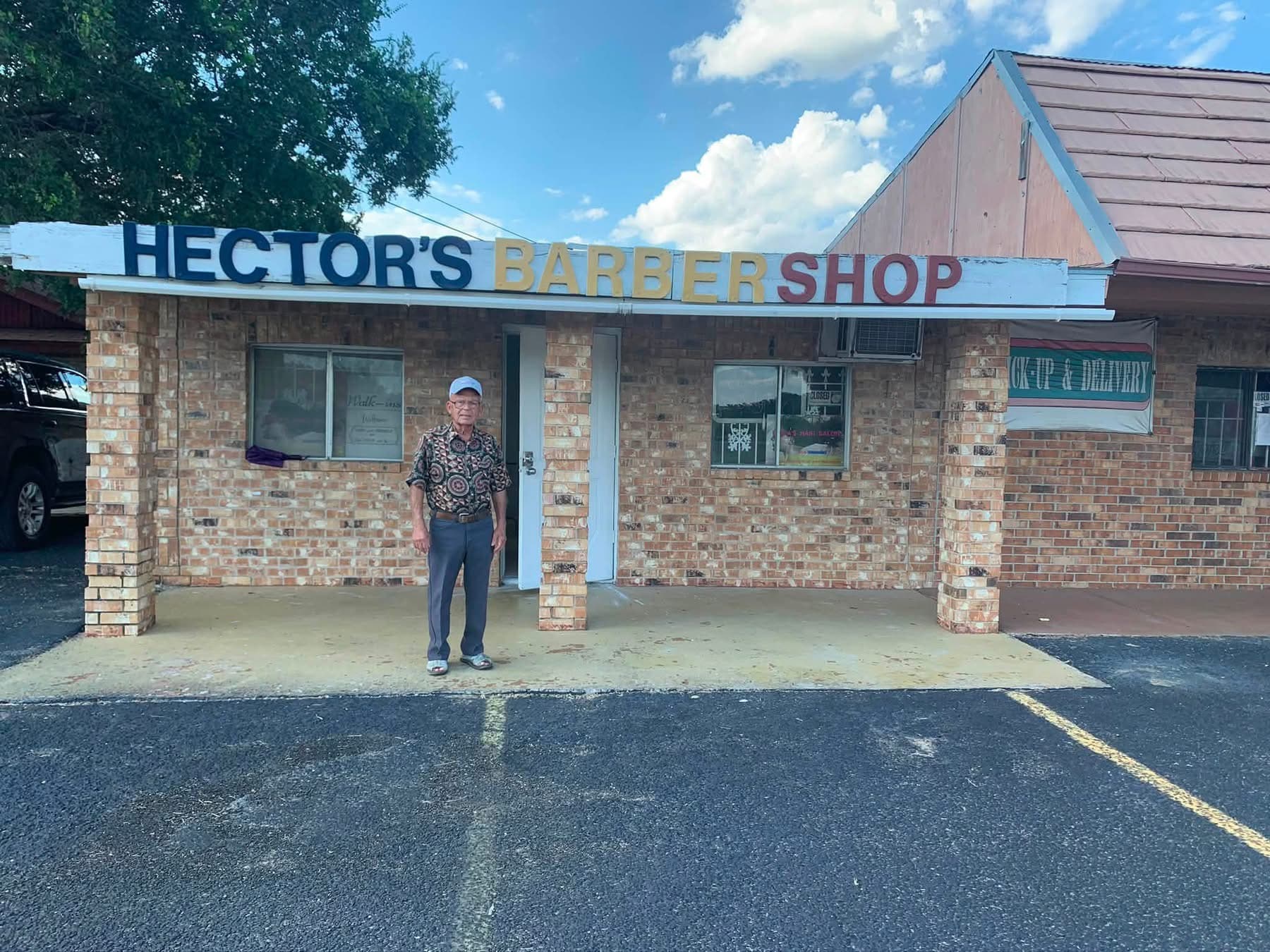 Karla's father standing in front of Hector's Barbershop in Edinburg